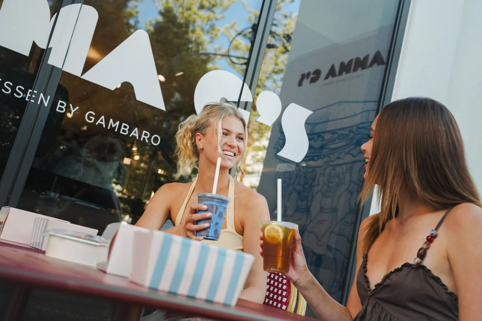 Two friends with iced drinks outside the Mamma G's shopfront